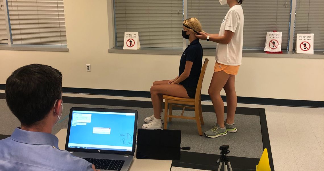 Student research assistants demonstrating use of IMU head band on pressure sensing mat