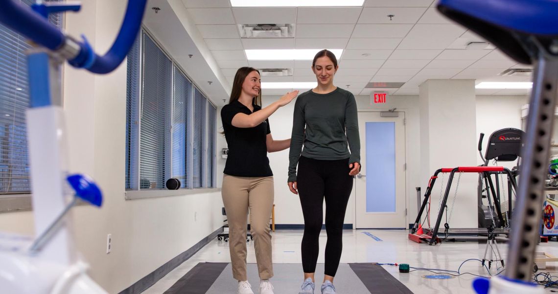 Participant and student research assistant walking across pressure sensitive mat